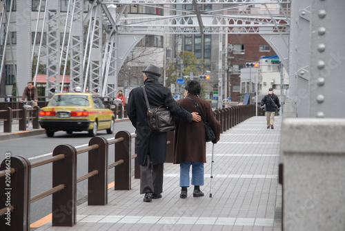 高齢者 後ろ姿 シニア シニア世代 二人 ２人 ふたり 夫婦 橋を渡る 橋 杖 歩道 歩く 散歩 街 町 冬 秋 支え合い 助け合う サポート 仲の良い 優しさ 優しい 思いやり 横 後 風景 背中