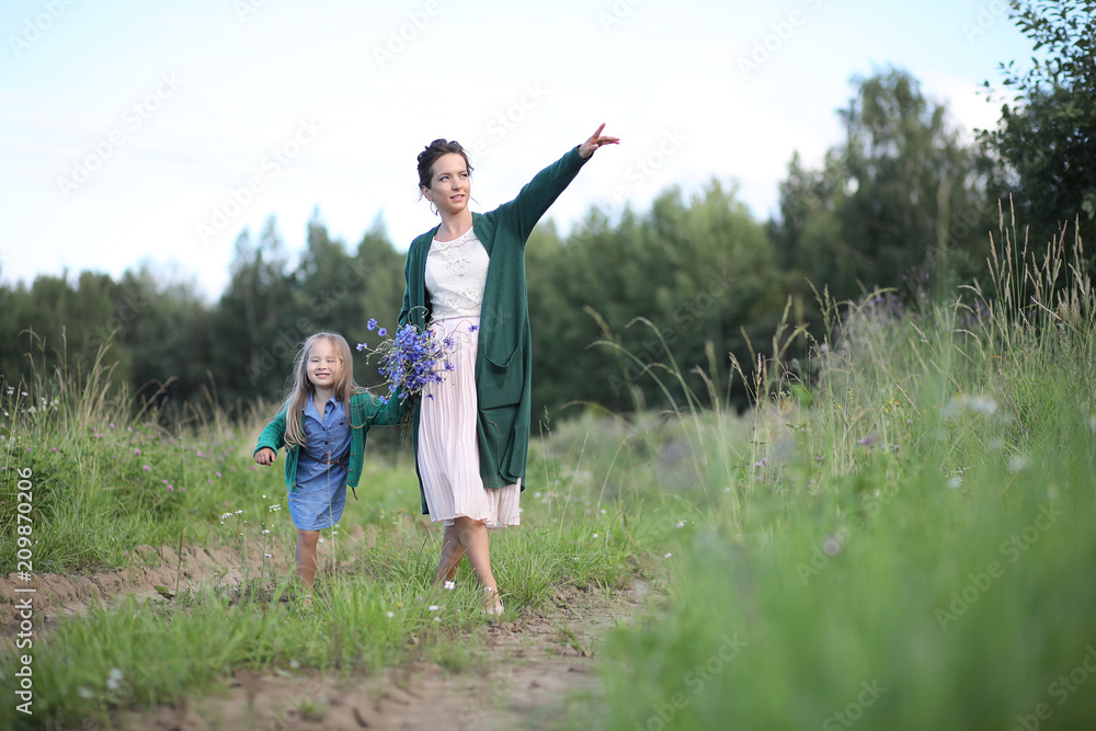 Mother with daughter walking on a road