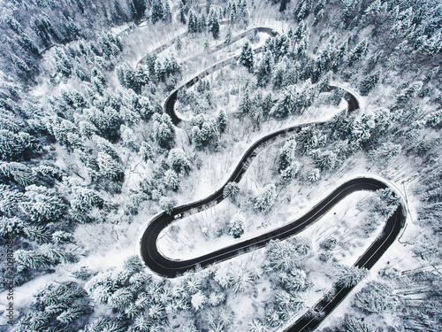 Snowy road in the forest. Extreme winding road high up in the mountains
