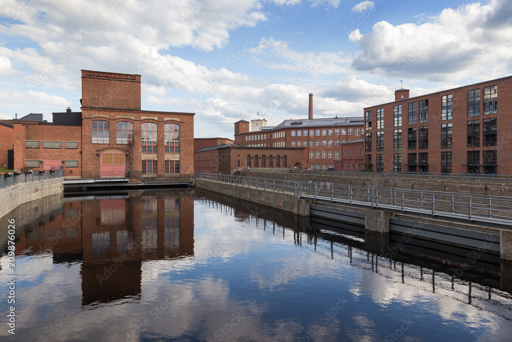 Old red brick industrial buildings along the Tammerkoski rapids in downtown Tampere, Finland on a sunny day. Old red brick industrial buildings along the Tammerkoski rapids in downtown Tampere, Finland on a sunny day.