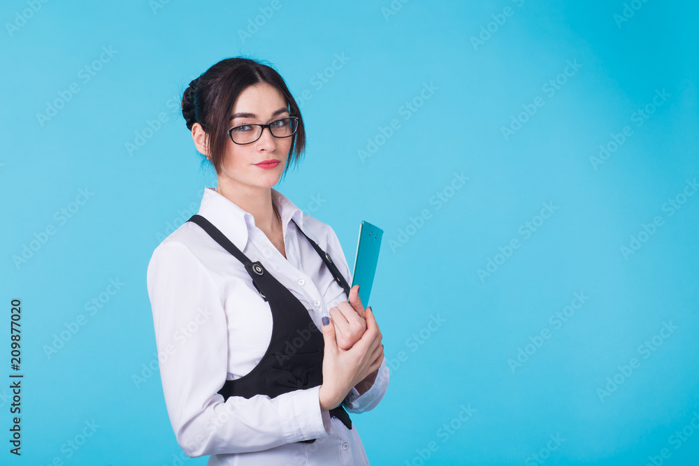 Portrait of young confident caucasian business woman with folder on blue background Portrait of young confident caucasian business woman with folder on blue background