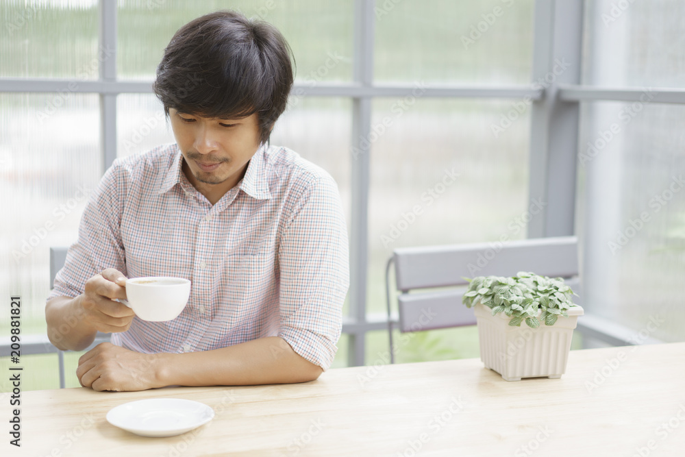Asian man drinking coffee in cafe