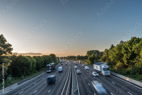 Sunset view heavy traffic moving at speed on UK motorway in England photo