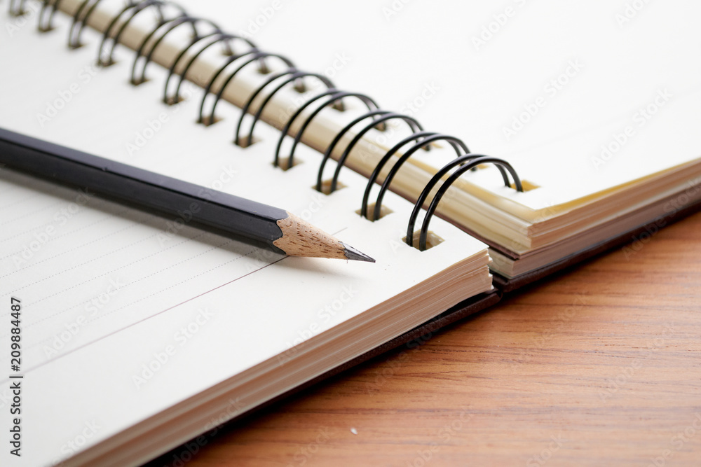 Writing on Notebook With Pencil