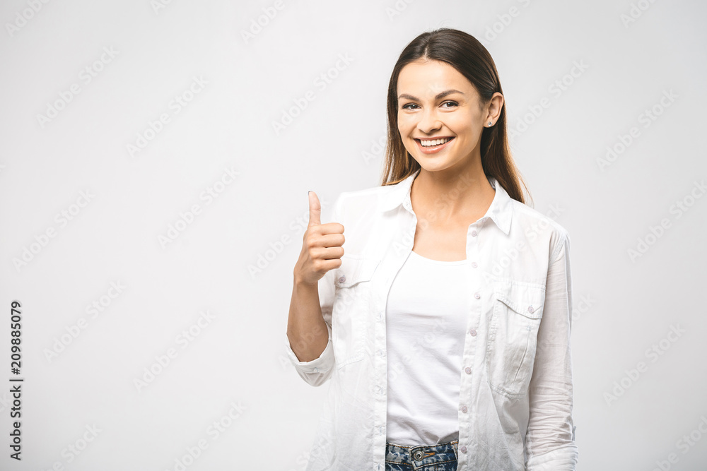 Young happy cheerful woman showing thumb up. Confident young businesswoman giving the thumbs up against a white background. Place for text. Young happy cheerful woman showing thumb up. Confident young businesswoman giving the thumbs up against a white background. Place for text.