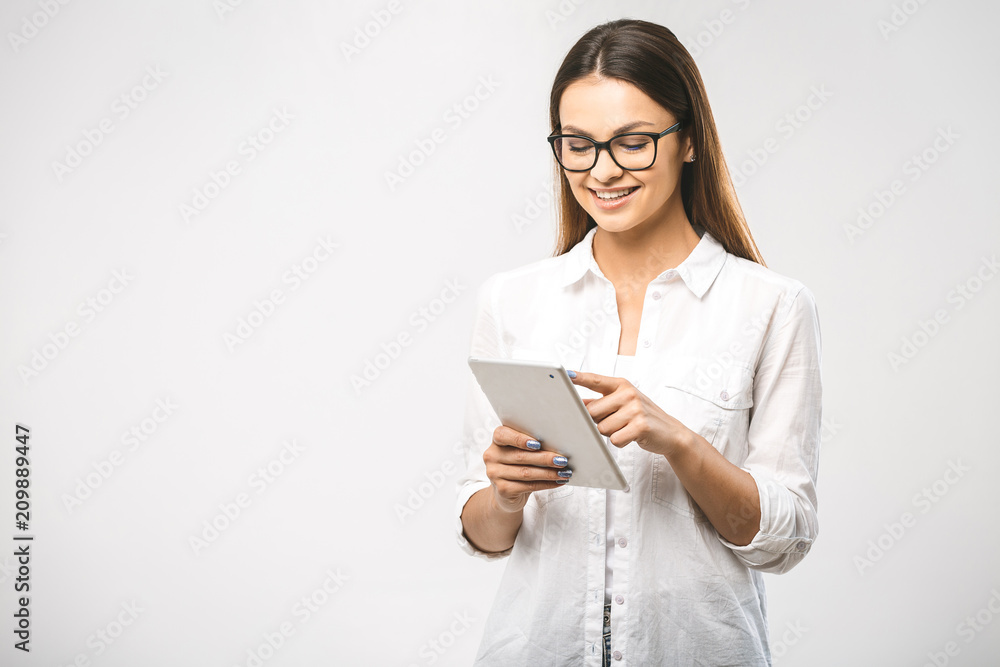 Portrait with copy space empty place of pretty charming confident trendy woman in classic shirt having tablet in hands looking at camera isolated on white background Portrait with copy space empty place of pretty charming confident trendy woman in classic shirt having tablet in hands looking at camera isolated on white background