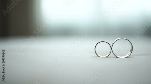 The female wedding ring is rolling to the male one. Wedding composition. No people. photo