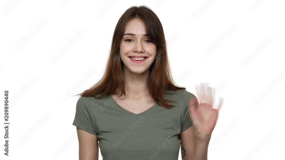 Portrait of joyful candid woman with beautiful auburn hair smiling on camera and welcoming with waving hand, isolated over white background. Concept of emotions Portrait of joyful candid woman with beautiful auburn hair smiling on camera and welcoming with waving hand, isolated over white background. Concept of emotions