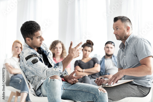 Foto Mixed-race teenager talking to a school counselor in detention