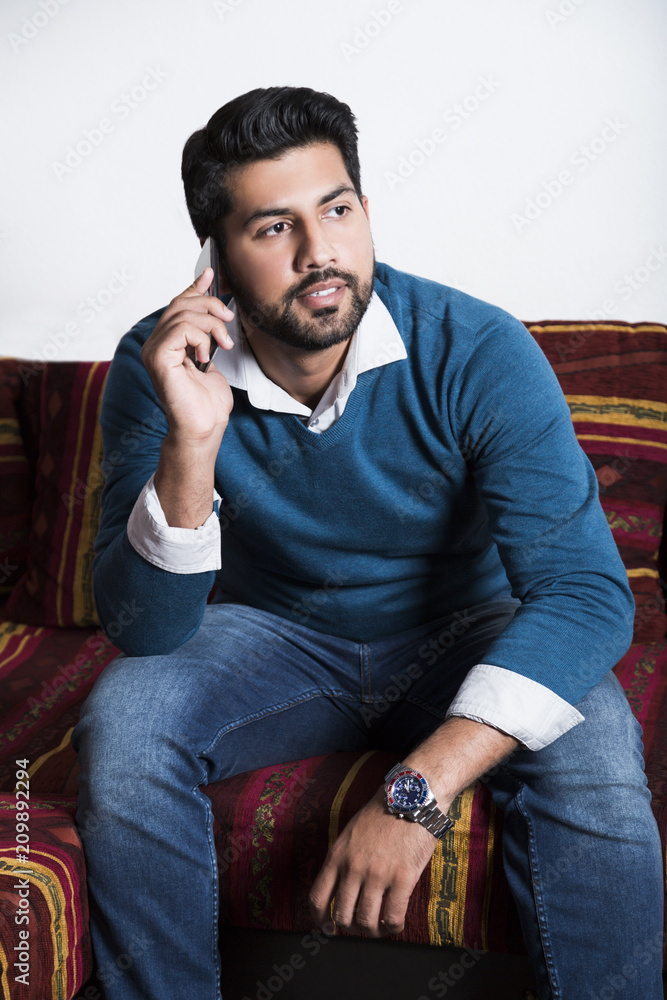 Smiling man sitting in casual with smart phone