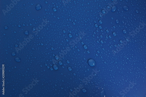 Water drops on flat blue surface