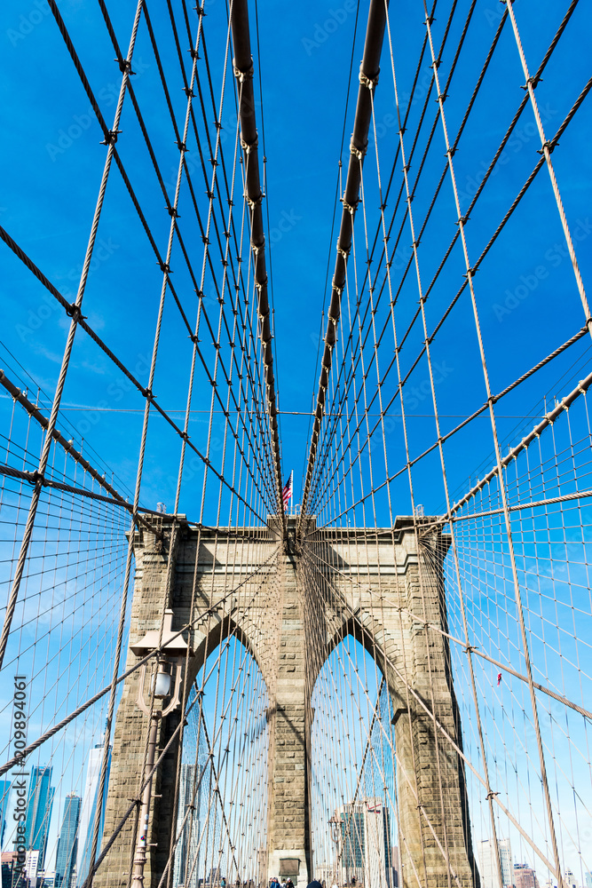 Fototapeta premium Brooklyn bridge over water, blue sky with sunshine