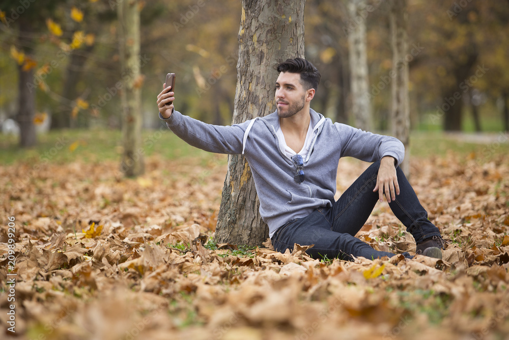 Handsome man in nature reading a book. Autumn leaves. Copy space Handsome man in nature reading a book. Autumn leaves. Copy space