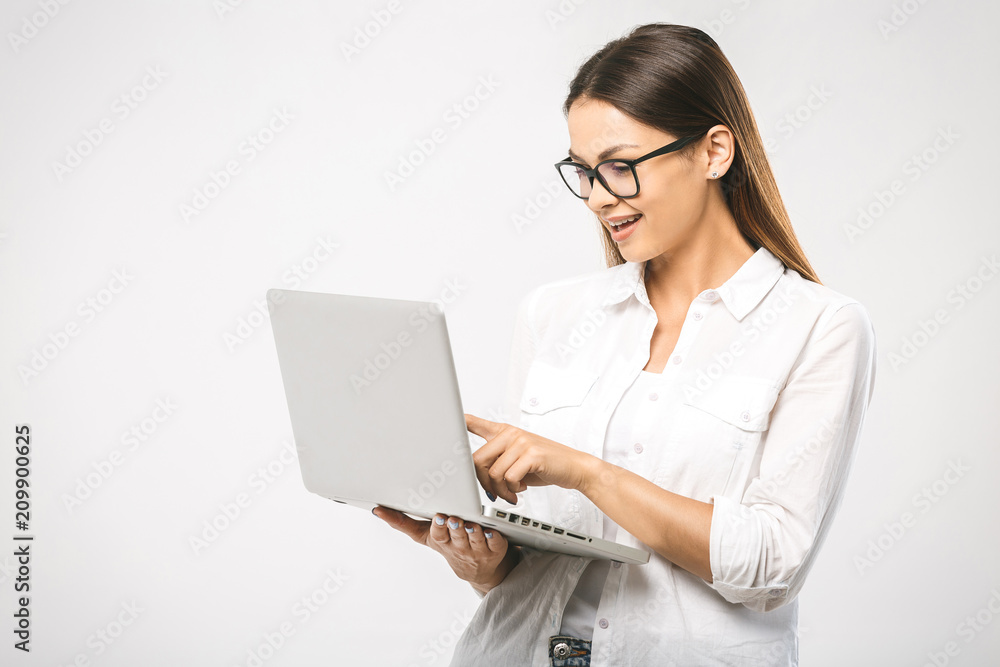 Portrait of happy surprised woman standing with laptop isolated on white background Portrait of happy surprised woman standing with laptop isolated on white background