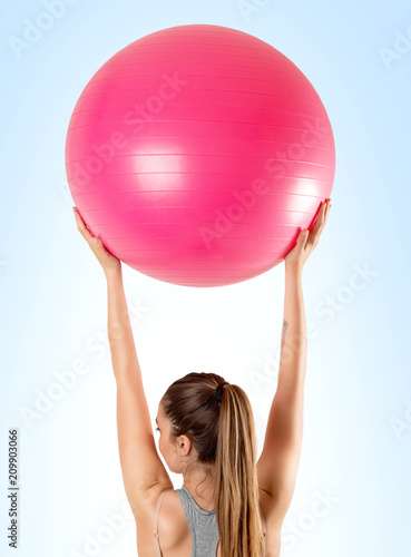 Pilates and fitness sport girl holding pink pilates ball viewed from the back. Healthy lifestyle © virtustudio