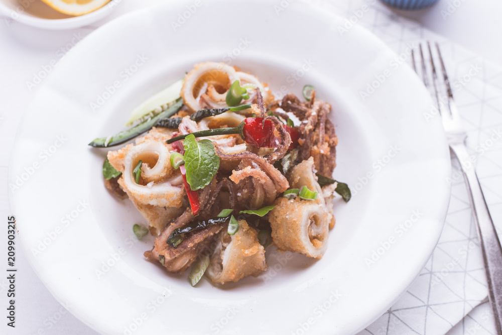 Fresh Fried Squids Calamari, Red Hot Chili Pepper and Green Mint Leaves on White Plate Fresh Fried Squids Calamari, Red Hot Chili Pepper and Green Mint Leaves on White Plate