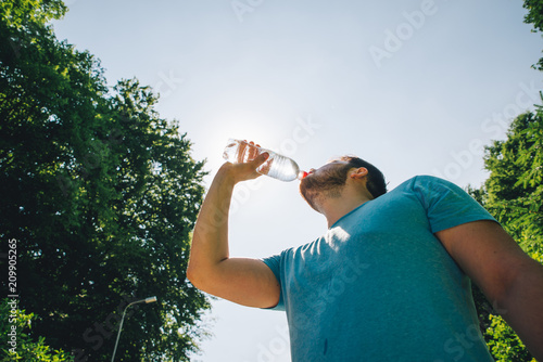 man drinking water in hot summer day. copy space