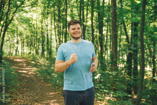 adult young man running in woods. copy space. smiling