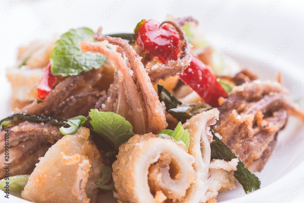 Greek Fried Squids Calamari with Red Chili Pepper and Fresh Mint Leaves on White Plate