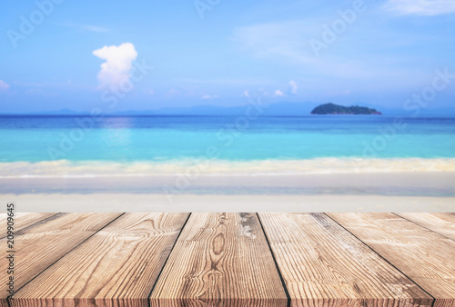 Wood table with blue sea and sand beach background 