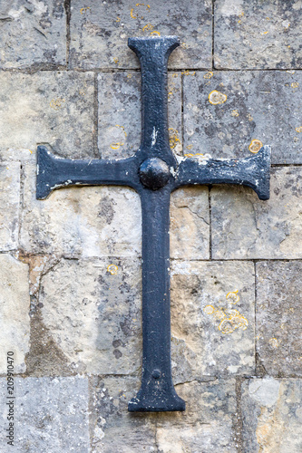 An iron cross on the side of a church