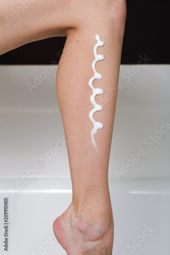 Female leg with the applied skin moistening cream
