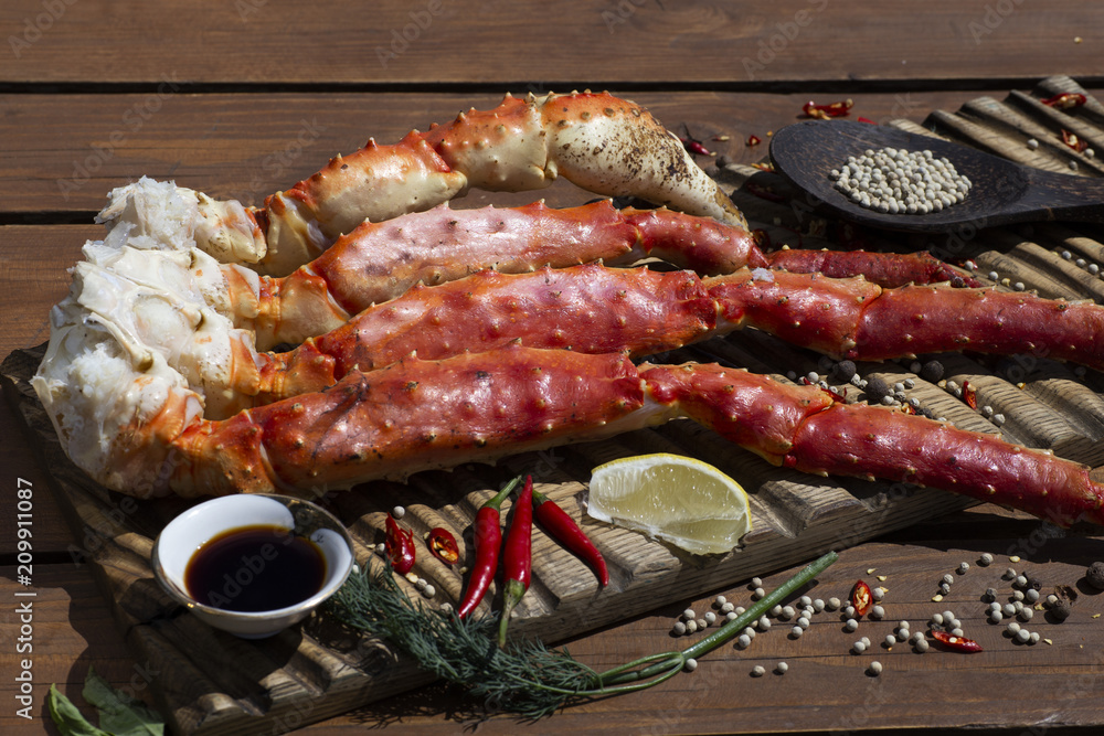 Fresh crab claws with sauce, pepper and lemon on vintage wooden background.
Fresh crab claws with sauce, pepper and lemon on vintage wooden background.