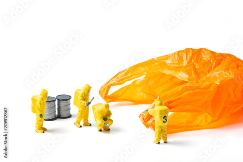 The figurines in protective suit examine an orange used plastic bag isolated on white background