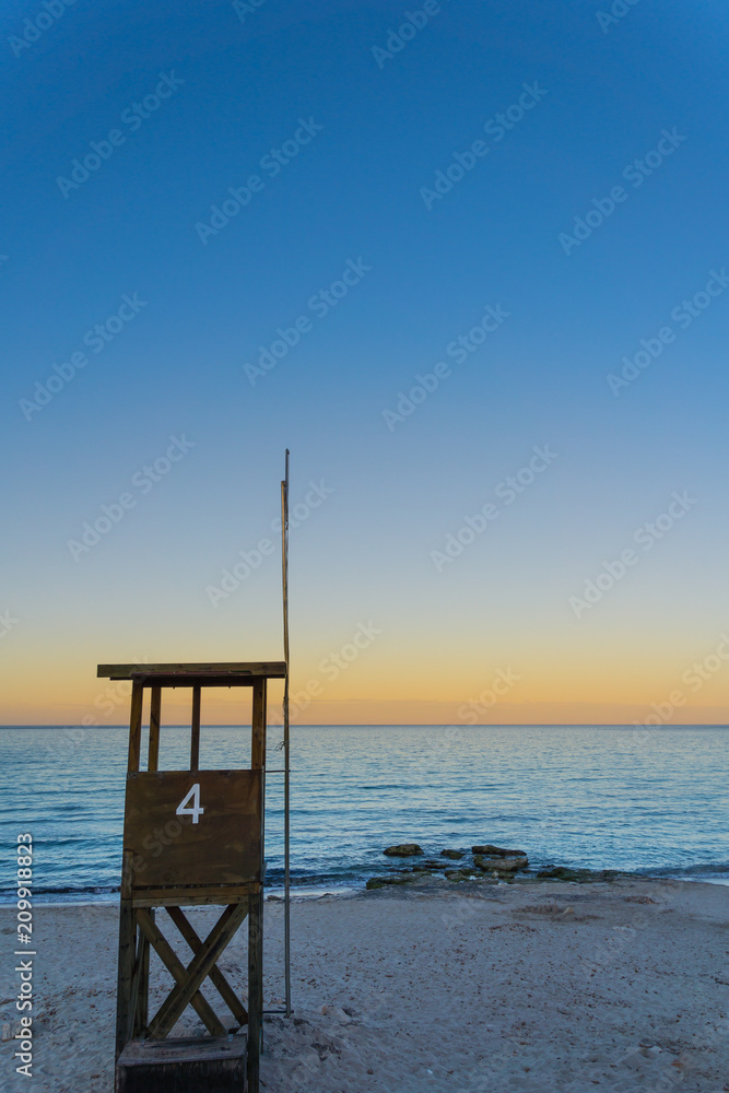 Mallorca, Lifeguard house at white sand beach on holiday island at sunset Mallorca, Lifeguard house at white sand beach on holiday island at sunset
