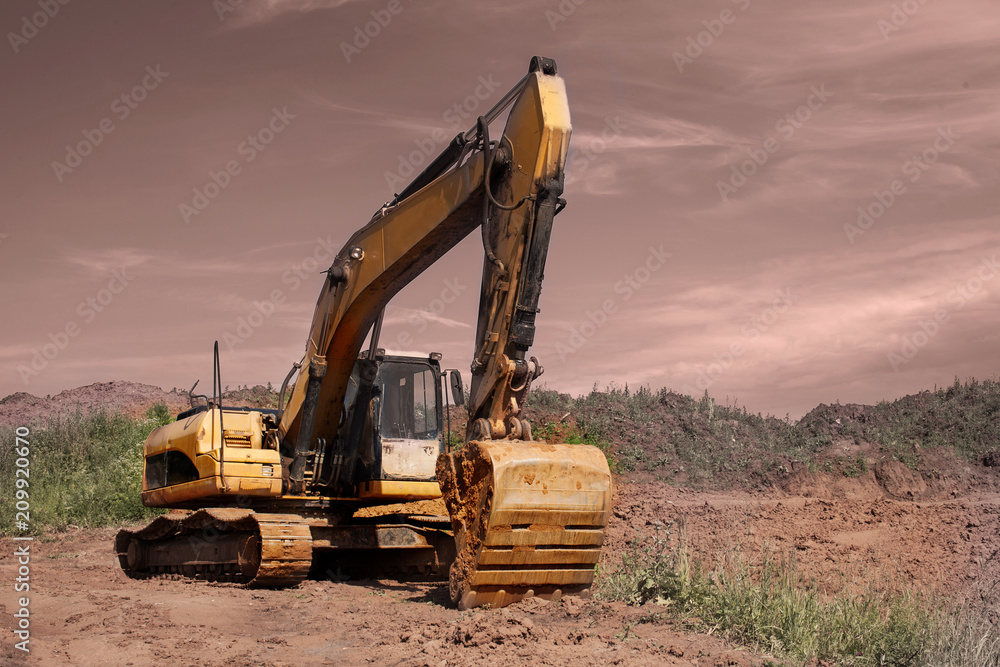 Orange excavator is on a backround of blue sky. Orange excavator is on a backround of blue sky.