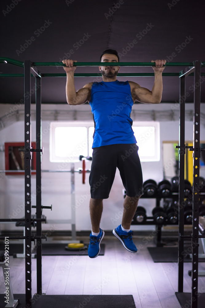 Fototapeta premium man doing pull ups on the horizontal bar