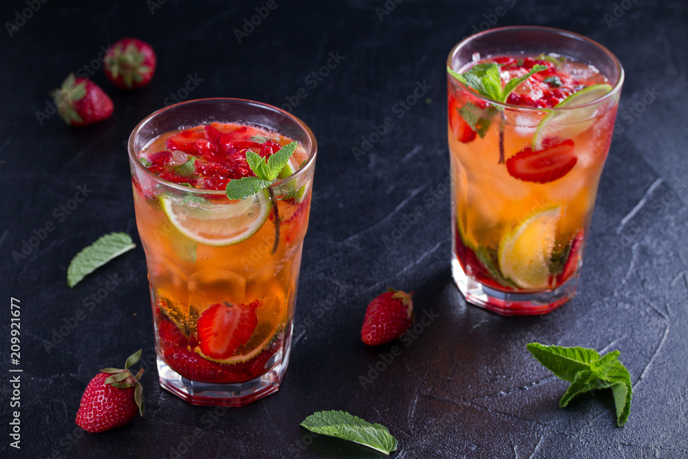 Strawberry mojito cocktail with berries, lime and mint. Summer berry cocktail on black background. horizontal Strawberry mojito cocktail with berries, lime and mint. Summer berry cocktail on black background. horizontal