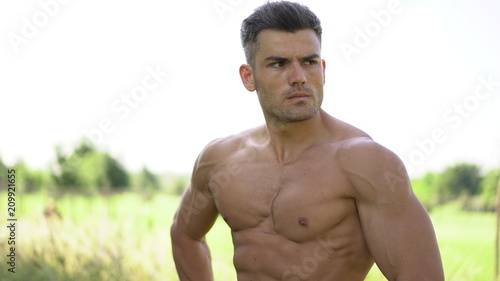 Outdoor portrait of a good looking fit male model with his shirt off