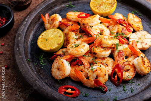 Prawns Shrimps roasted on  pan with lemon and garlic on dark rustic background. top view. photo