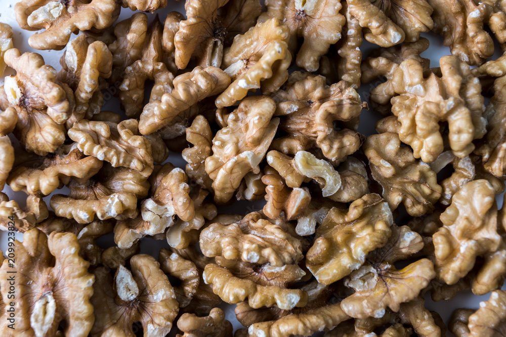 Pile of walnuts on a white table. Close up view. Nuts for health Pile of walnuts on a white table. Close up view. Nuts for health