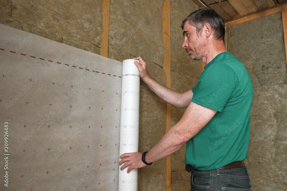 worker insulates a country house of mineral wool worker insulates a country house of mineral wool