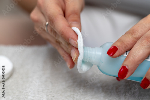 Woman removes red nail polish with nail polish remover