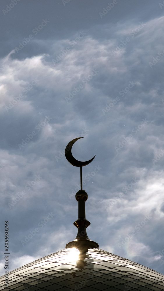 Φωτογραφία The symbol of Islam is a golden crescent moon on top of the mosque minaret on the blue evening of the morning sky with clouds