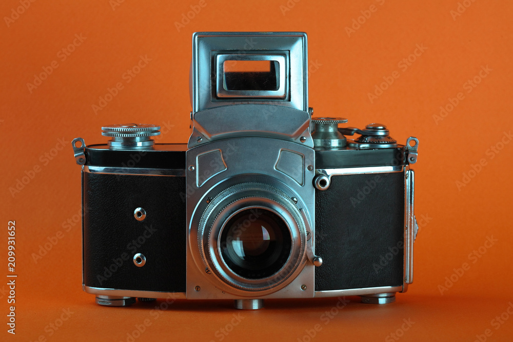 The old 35 mm SLR camera on a orange background.