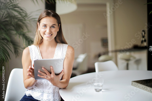 Smiling young woman holding a tablet