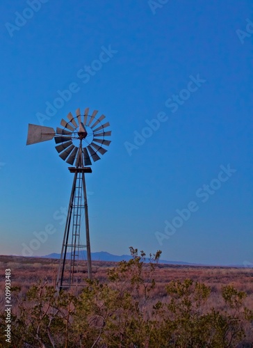Old Lone Windmill Sits Still at Dusk with Mountain in the Distant Background