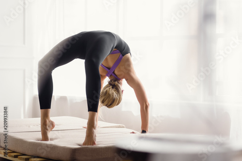Fit slim athletic yoga woman in bridge position