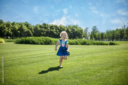 A little girl is running in the park.