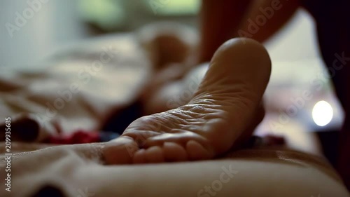 A professional thai masseur massaging client s foot with oil in a daylight, close-up. A masseuse s hands on client s skin. A spa client receiving a great thai massage. photo