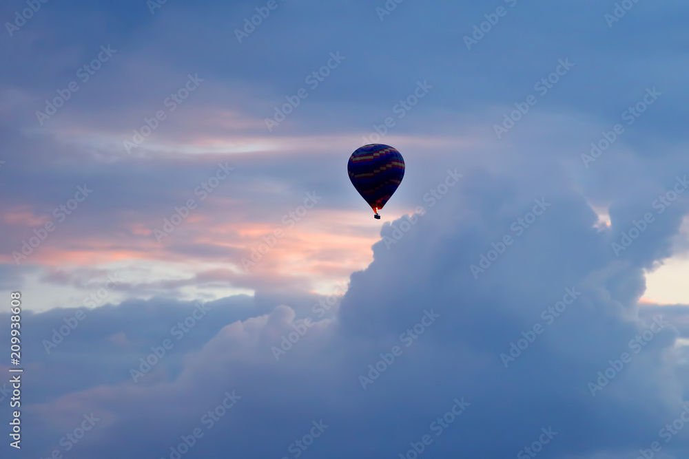 Fototapeta balloon with people flying in the colored sky