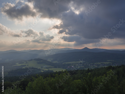 Lusatian Mountains (luzicke hory) panorama,view from Hochwald (Hvozd) mountain on czech german borders with sun rays blue green hills forest and pink cloudy sunset sky background