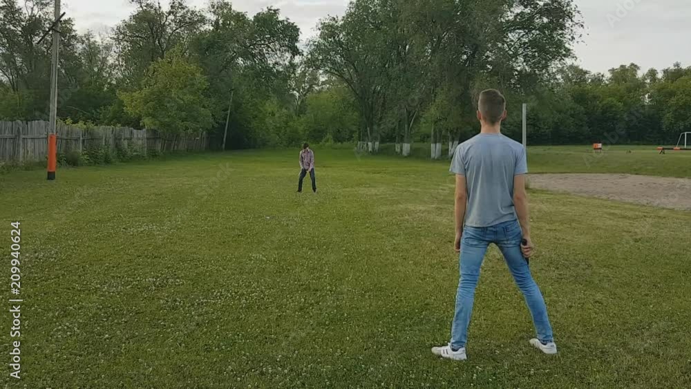 two brothers play badminton on the green grass in the Park on a summer evening. two brothers play badminton on the green grass in the Park on a summer evening.