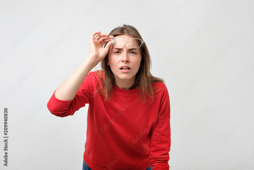 Young caucasian woman wearing glasses looking at camera with doubt and distrust Young caucasian woman wearing glasses looking at camera with doubt and distrust