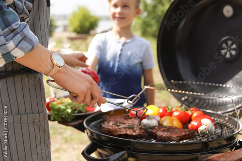 Happy family having barbecue with modern grill outdoors
