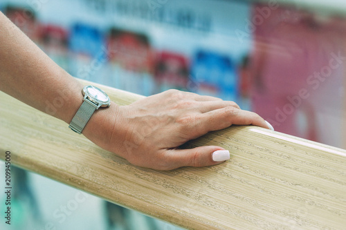 A beautiful female hand holds onto the handrail in the mall